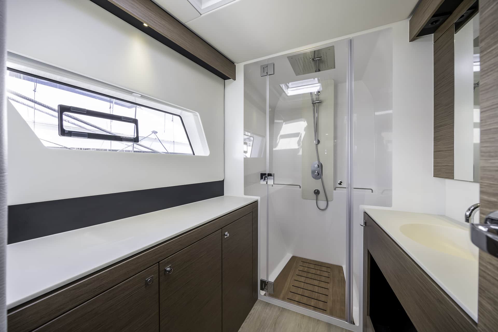 Luxury catamaran bathroom with walk-in shower aboard Seven Days, available for private yacht charters from Poole Harbour.