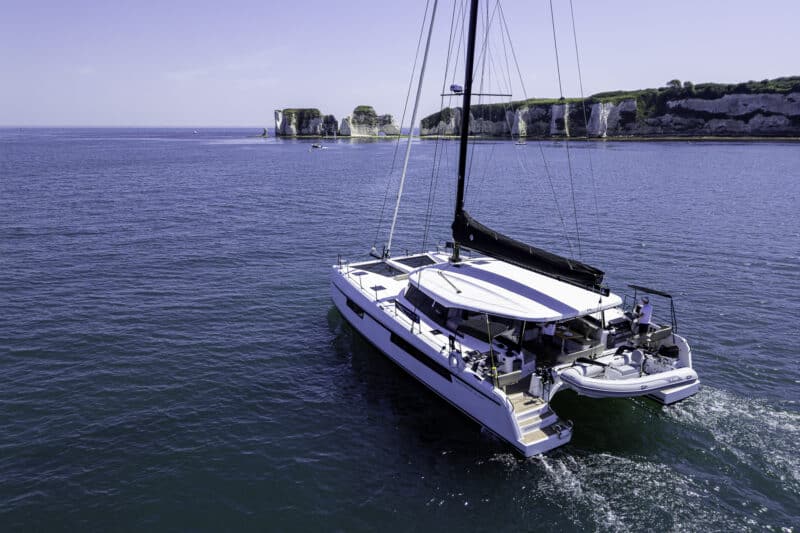 Private yacht charter aboard the Seven Days catamaran cruising past Old Harry Rocks on the Dorset Coast.