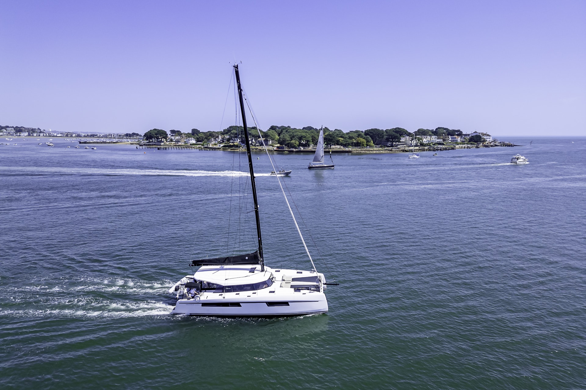 Private yacht charter aboard the Seven Days catamaran cruising through Poole Harbour near Sandbanks and Brownsea Island.