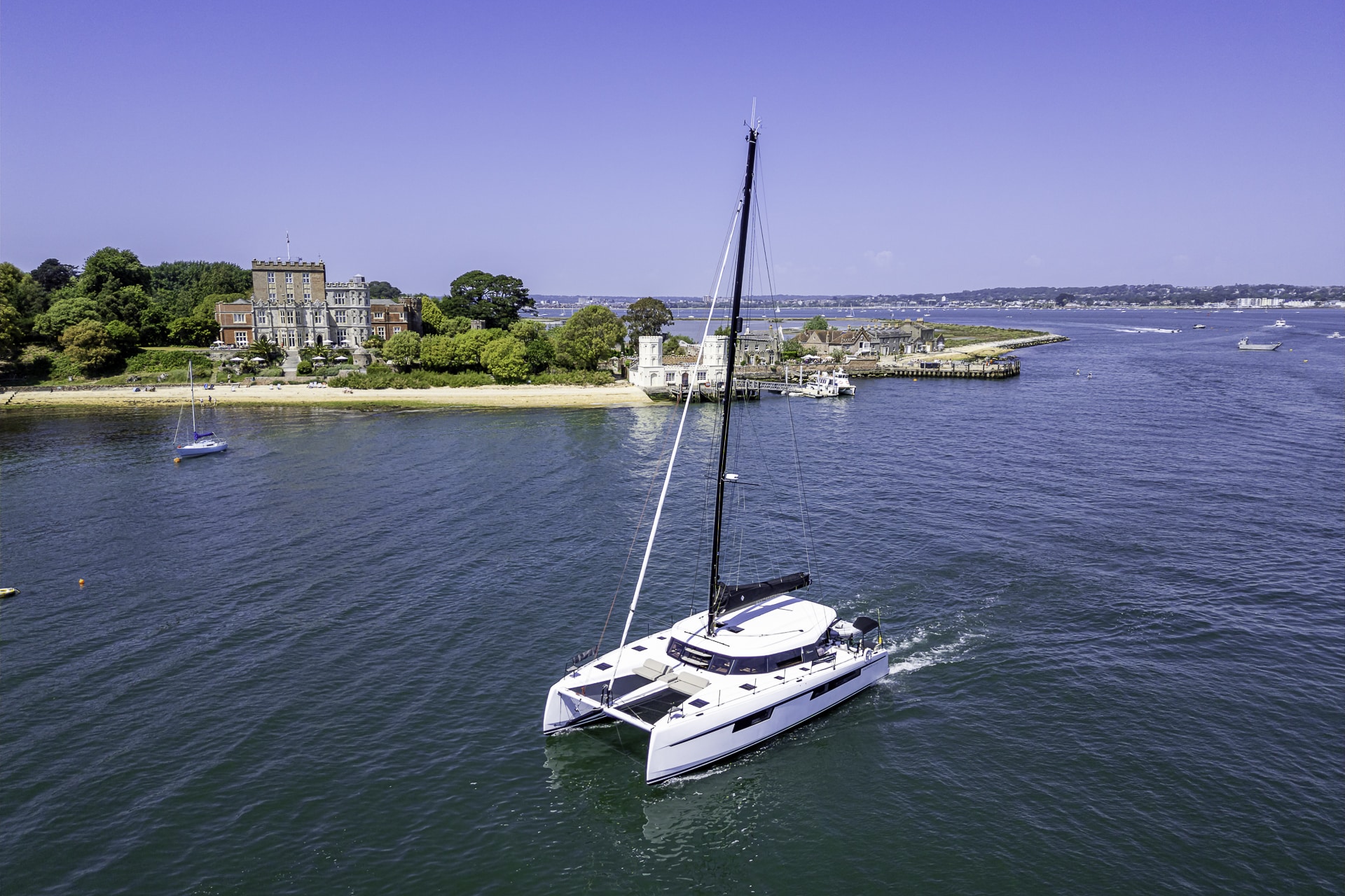 Seven Days luxury catamaran exploring Poole Harbour with Brownsea Island and Brownsea Castle in the background.
